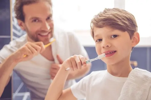 father and son brushing teeth