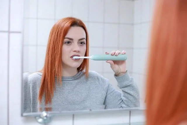 young woman brushing teeth